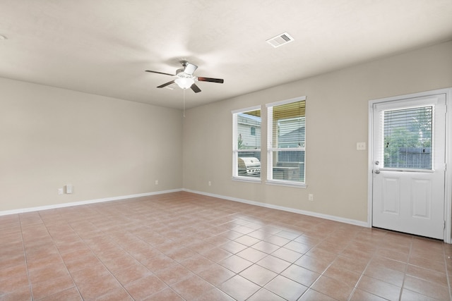 tiled spare room with ceiling fan