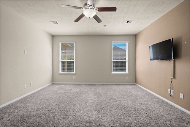 carpeted empty room featuring ceiling fan and a textured ceiling