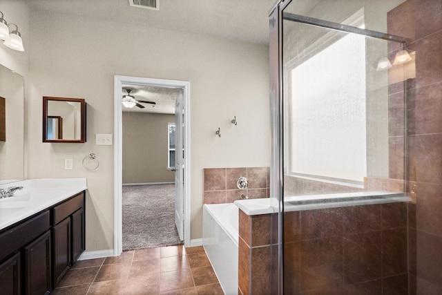 bathroom with ceiling fan, tile patterned flooring, vanity, and plus walk in shower