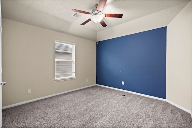 carpeted spare room with ceiling fan