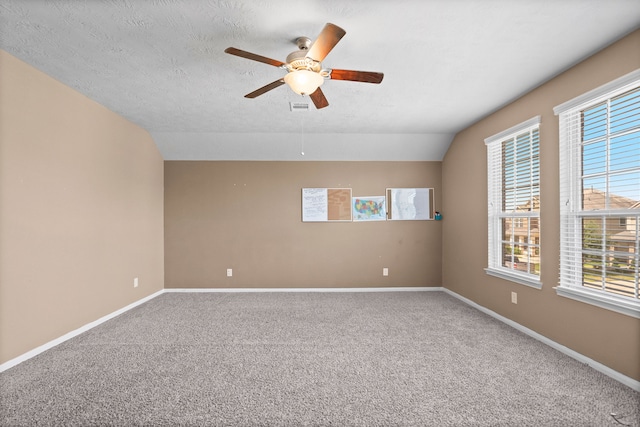 unfurnished room with carpet, a healthy amount of sunlight, and lofted ceiling