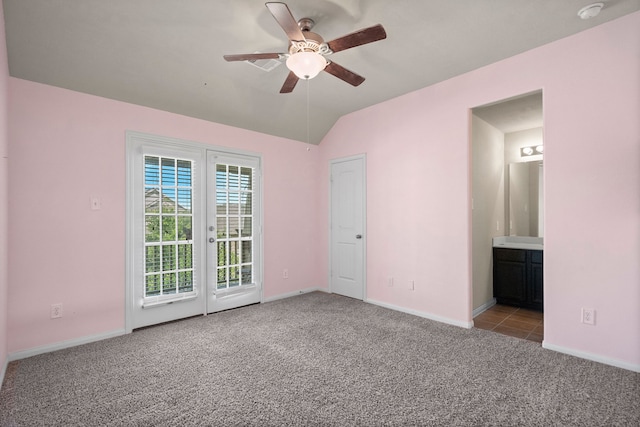 carpeted empty room featuring vaulted ceiling and ceiling fan