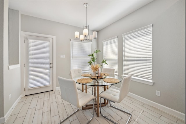 dining room with light wood-type flooring and an inviting chandelier