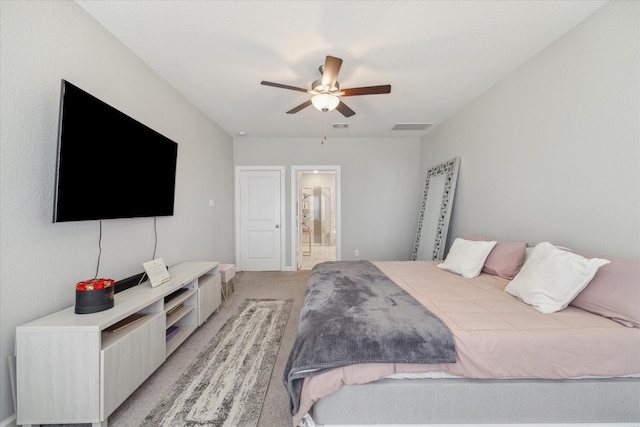 carpeted bedroom featuring ceiling fan and ensuite bath