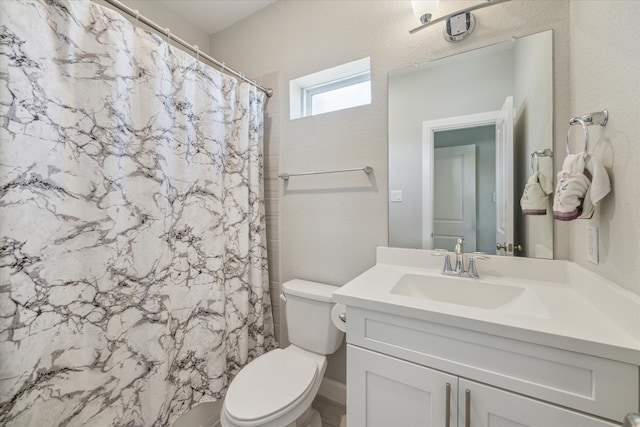 bathroom featuring vanity, toilet, and curtained shower