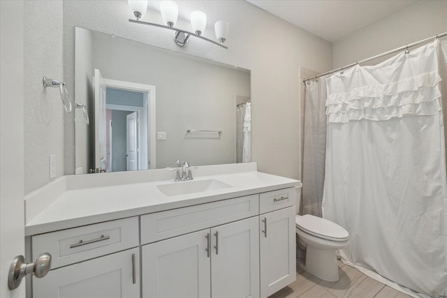 bathroom featuring toilet, walk in shower, vanity, and wood-type flooring