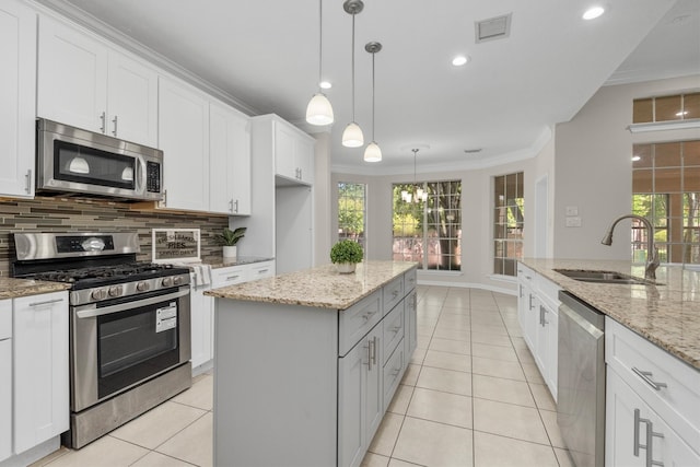 kitchen with white cabinetry, appliances with stainless steel finishes, a kitchen island, and sink