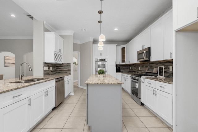 82 Champion Villa Dr, Houston, TX 77069 - kitchen featuring a sink, crown molding, backsplash, white cabinets, and appliances with stainless steel finishes