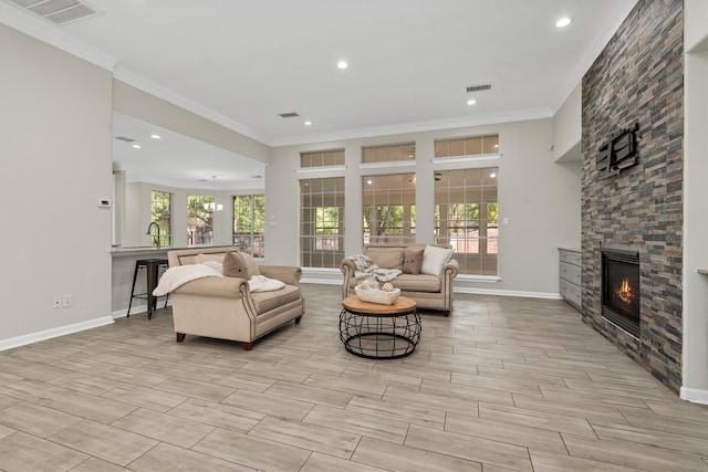 living room with ornamental molding, a fireplace, light hardwood / wood-style floors, and a wealth of natural light