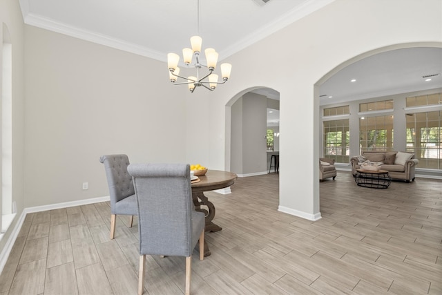 dining area with light wood-type flooring, a chandelier, and ornamental molding