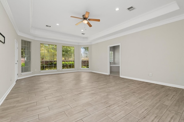 spare room with ceiling fan, ornamental molding, light hardwood / wood-style flooring, and a raised ceiling