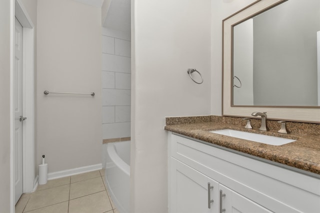 bathroom with a tub to relax in, vanity, and tile patterned floors