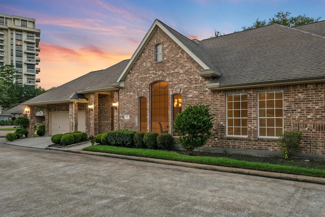 82 Champion Villa Dr, Houston, TX 77069 - french provincial home featuring driveway, an attached garage, a shingled roof, and brick siding