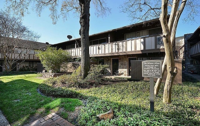 back of property with a balcony and a yard