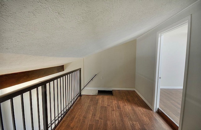 hall featuring a textured ceiling and dark hardwood / wood-style flooring