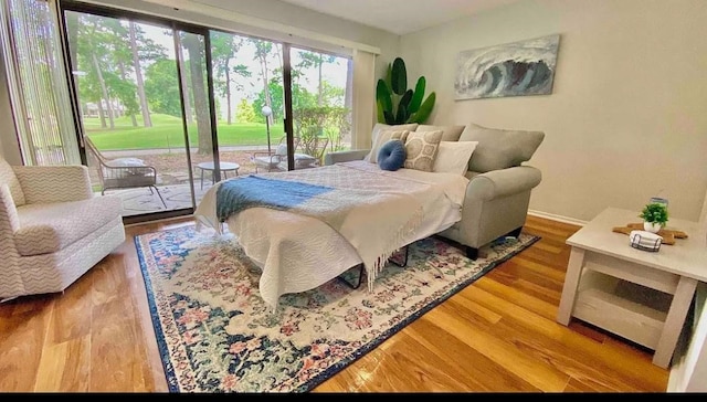 bedroom with access to outside and hardwood / wood-style flooring