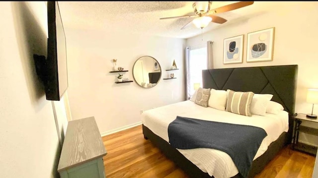 bedroom with ceiling fan, a textured ceiling, and wood-type flooring