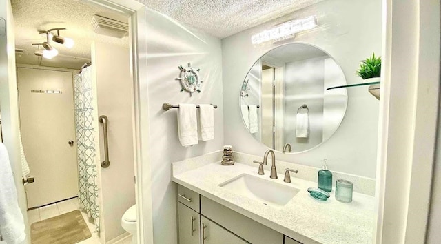 bathroom featuring vanity, toilet, a textured ceiling, tile patterned flooring, and a shower with shower curtain