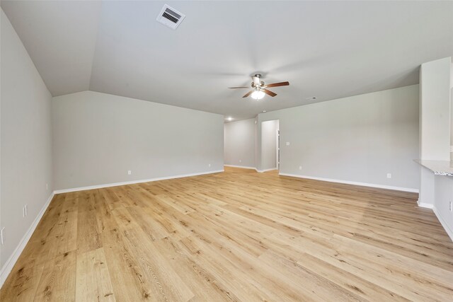 empty room featuring lofted ceiling, light hardwood / wood-style floors, and ceiling fan