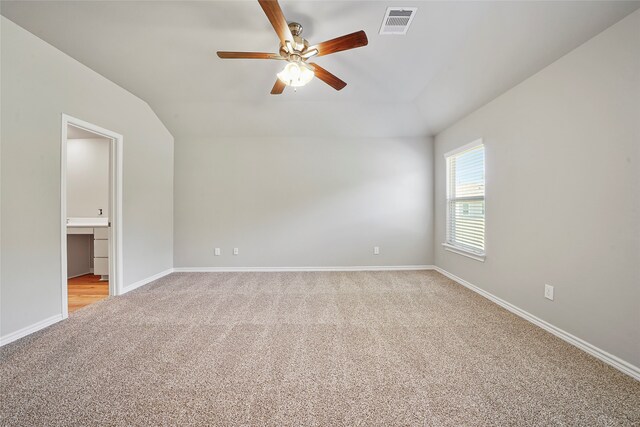 empty room featuring lofted ceiling, ceiling fan, and light carpet