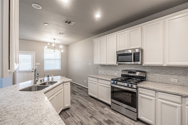 kitchen featuring sink, stainless steel appliances, light hardwood / wood-style floors, and white cabinetry