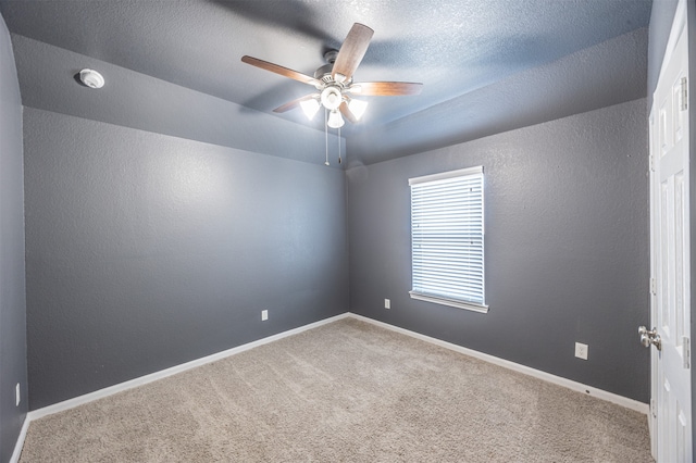 carpeted spare room with ceiling fan and a textured ceiling