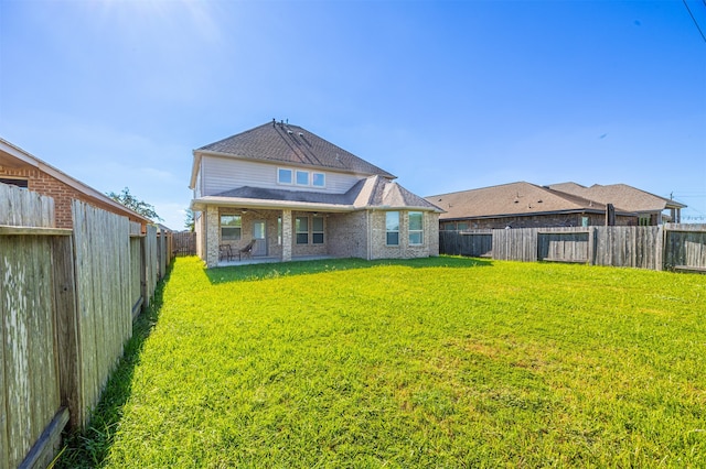 rear view of house featuring a yard