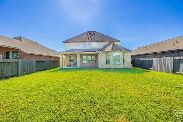 rear view of house featuring a lawn and a patio area