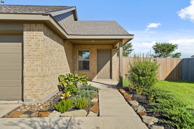 doorway to property with a lawn and a garage