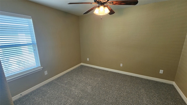 empty room featuring ceiling fan and dark colored carpet