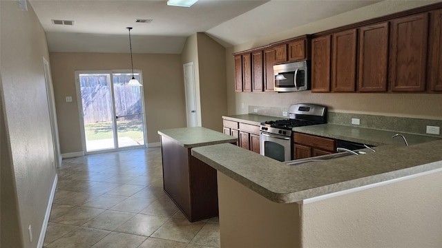 kitchen featuring lofted ceiling, a kitchen island, hanging light fixtures, stainless steel appliances, and sink