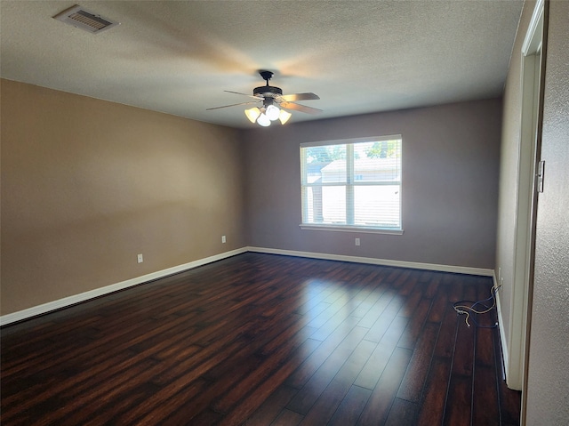 empty room featuring ceiling fan, a textured ceiling, and dark hardwood / wood-style floors