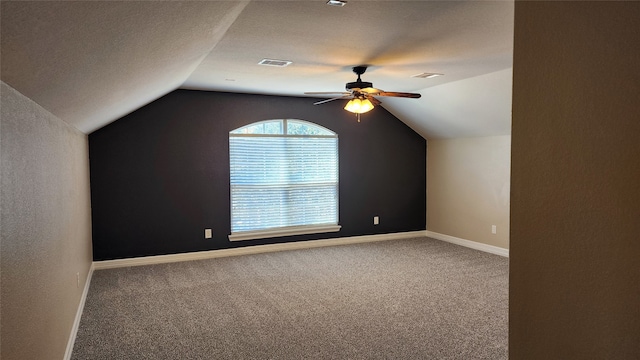 bonus room featuring lofted ceiling, a textured ceiling, carpet, and ceiling fan