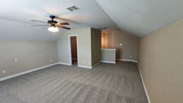 bonus room featuring a textured ceiling, vaulted ceiling, carpet floors, and ceiling fan