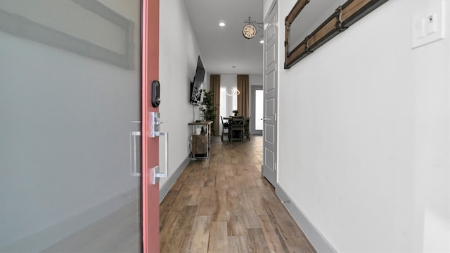 hallway with hardwood / wood-style flooring