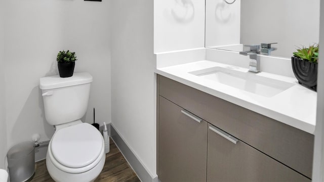 bathroom with vanity, toilet, and hardwood / wood-style flooring