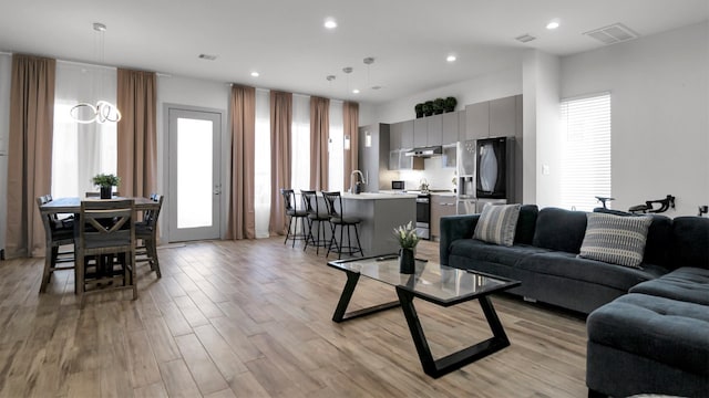 living room with sink and light hardwood / wood-style flooring