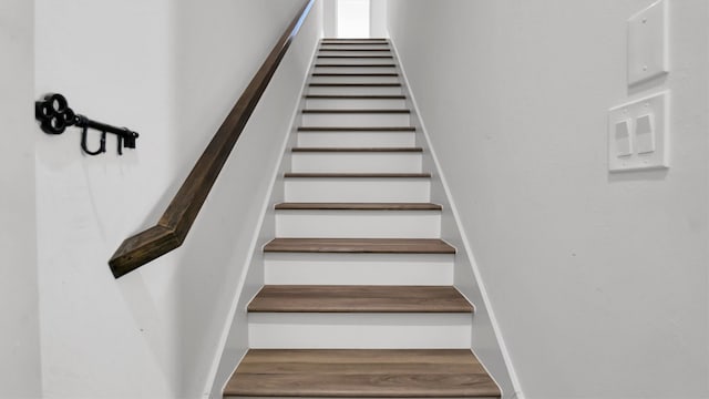 stairs featuring hardwood / wood-style floors