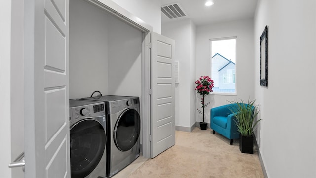 clothes washing area with light colored carpet and washing machine and dryer