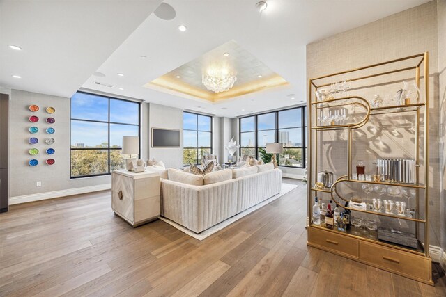 living room with wood-type flooring and a tray ceiling