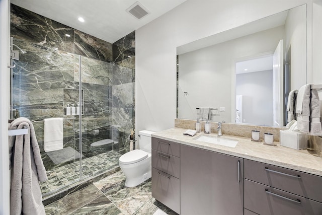 bathroom featuring vanity, toilet, and a shower with door