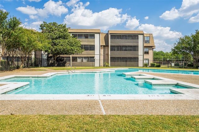 view of swimming pool featuring a hot tub