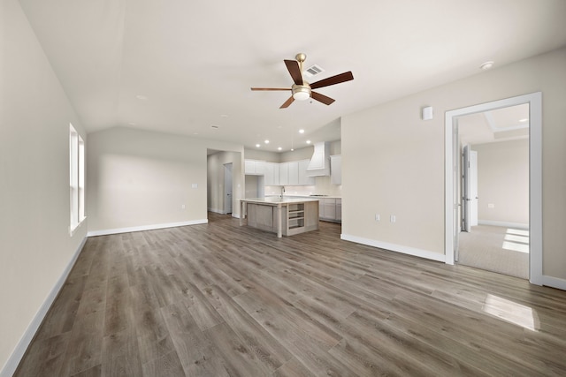 unfurnished living room with hardwood / wood-style flooring and ceiling fan