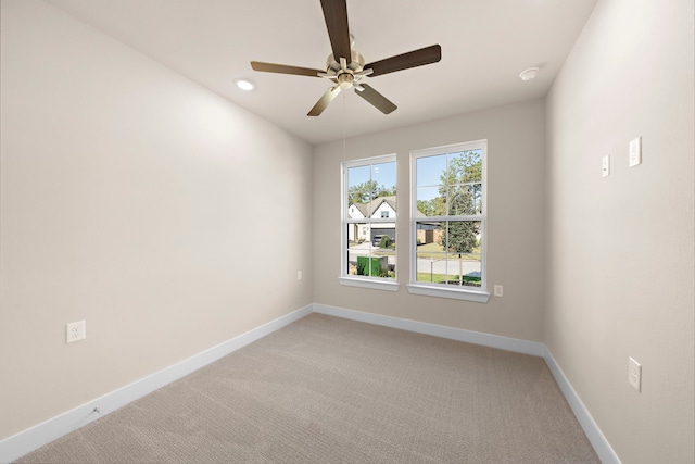 empty room featuring ceiling fan and light colored carpet