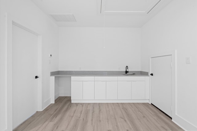 clothes washing area with light hardwood / wood-style flooring and sink