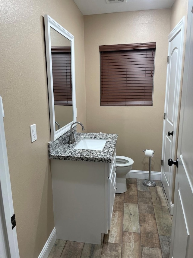 bathroom featuring hardwood / wood-style floors, vanity, and toilet