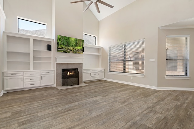 unfurnished living room with light hardwood / wood-style floors, high vaulted ceiling, and a wealth of natural light