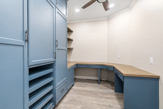 office area featuring light hardwood / wood-style flooring, built in desk, ceiling fan, and ornamental molding