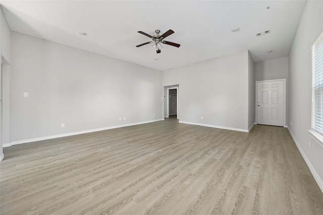 spare room featuring a ceiling fan, visible vents, baseboards, and light wood-type flooring