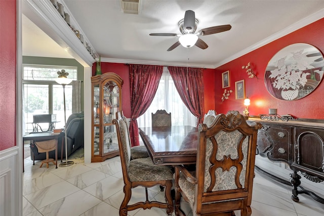 dining space featuring ceiling fan and crown molding